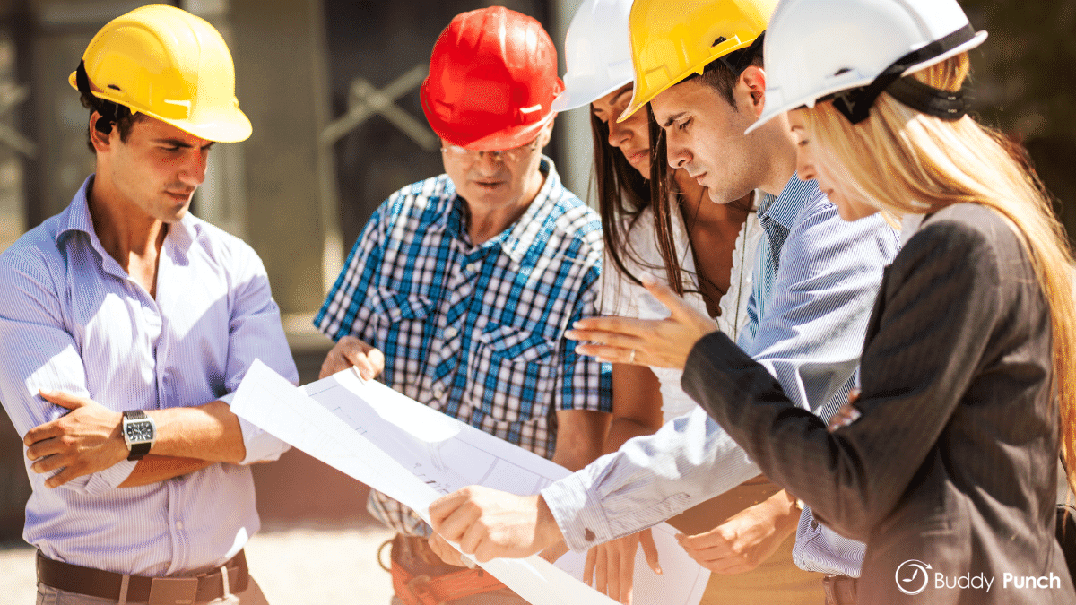 In field construction workers and office employees discussing details of a project. 