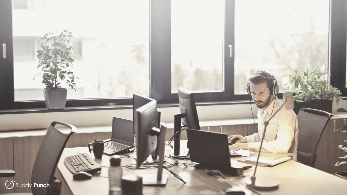 Man sitting at desk using online solutions to help him manager customer support.