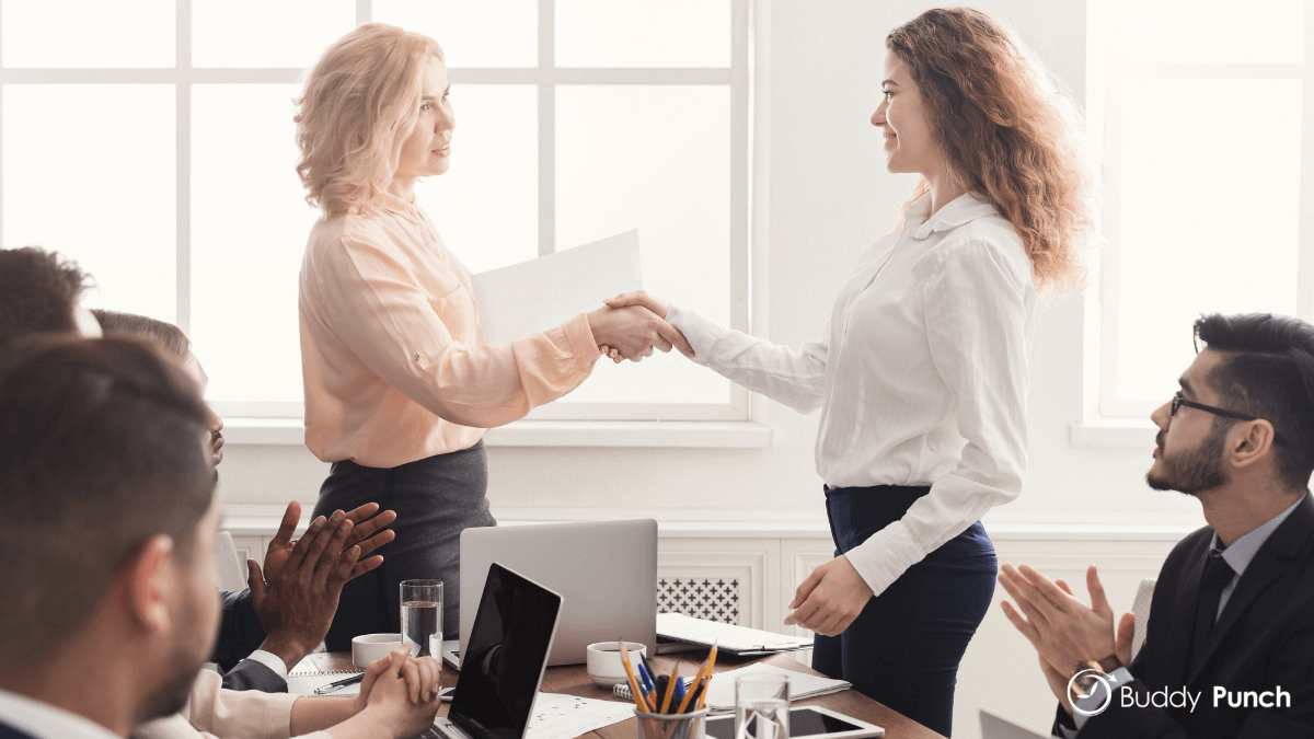 Manager acknowledging the work of one of her employees who has perfected her time management technique with the help of employee time clock software.