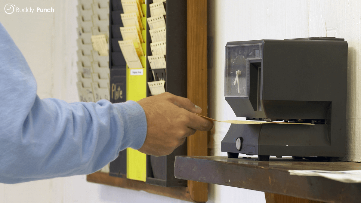 Man using a traditional punch clock system to track their time. 