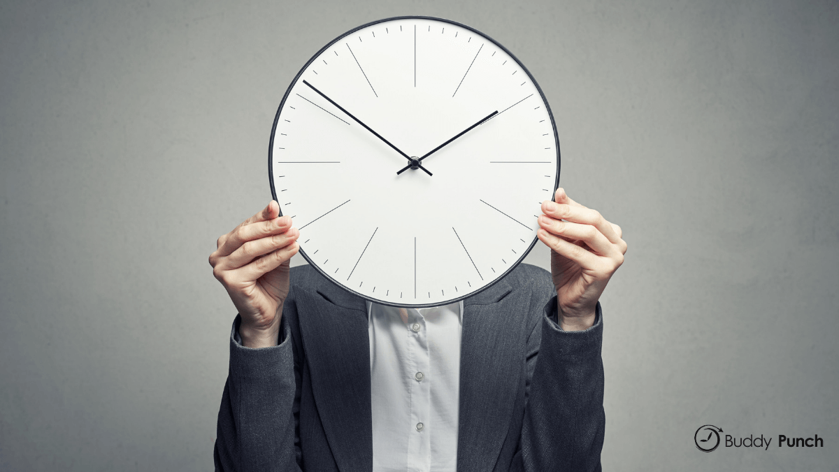 Woman holding time clock in front of face.