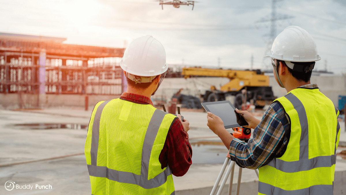 Project manager using drone to survey the construction site and their employees.