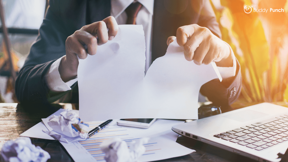 Manager shredding old time sheets that are no longer being used. 